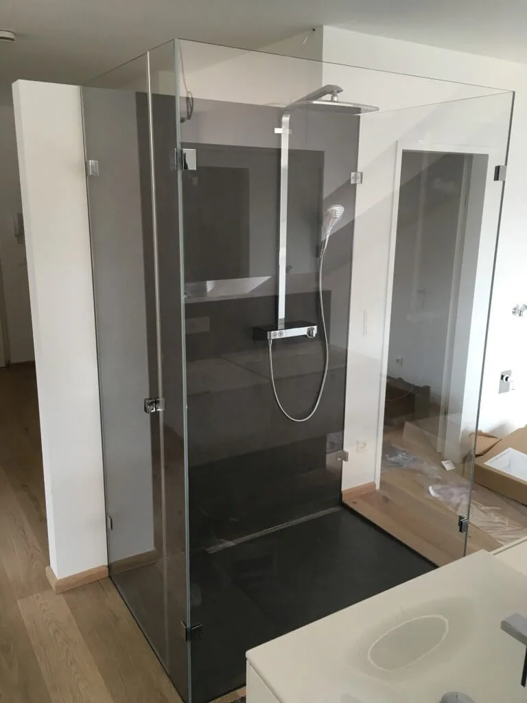 Glasdusche mit Eckeinstieg und Regendusche in einem hellen Bad