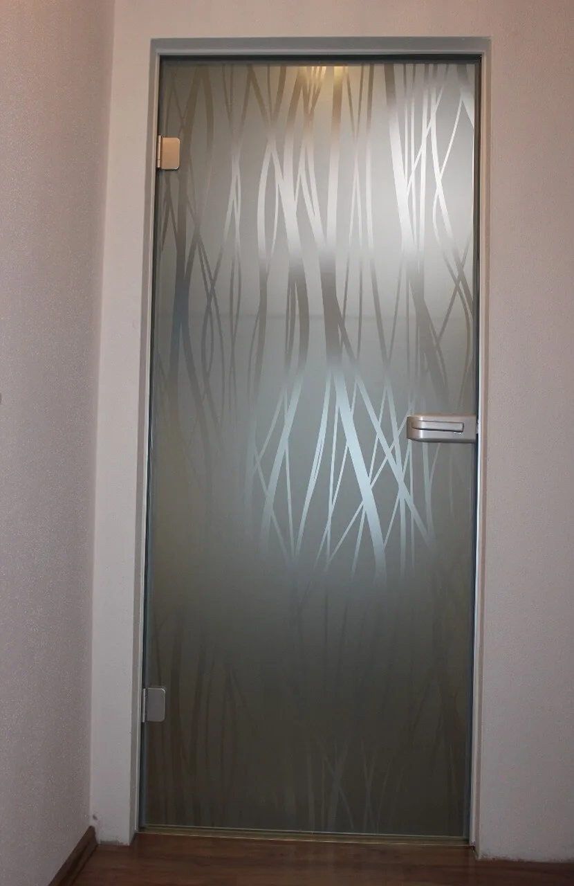Glastür mit sandgestrahltem Gräsermotiv in einem hellen Flur