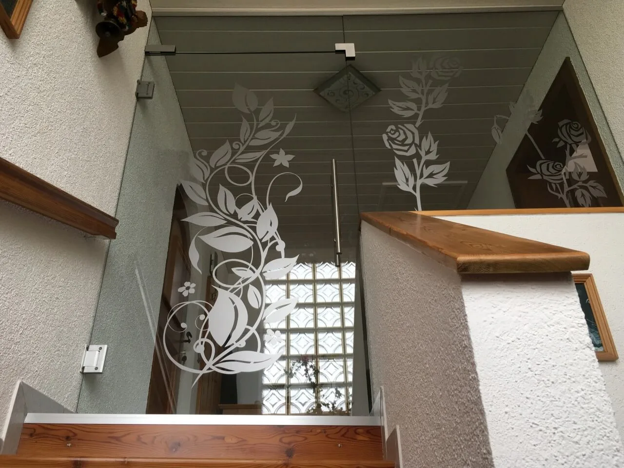 Glastür mit sandgestrahltem Rosen- und Rankenmotiv in einem Stiegenhaus